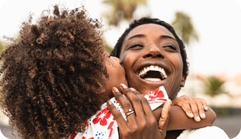 Mulher Negra abrançando uma criança menina negra felizes 